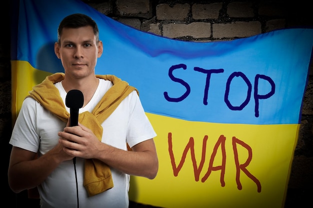 Journalist near Ukrainian flag with words Stop War