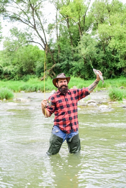 The joy of Getting Best hobby and sport activity summer weekend Happy fly fishing fisherman show fishing technique use rod bearded fisher in water mature man fly fishing man catching fish