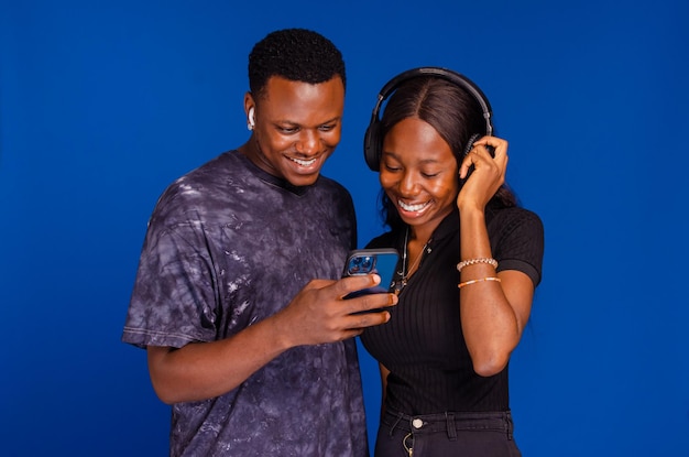 Joyful african american man and woman using smartphone together entertainment concept