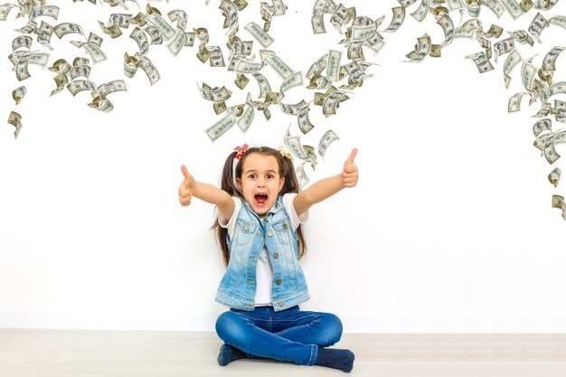 joyful beautiful little girl. cash dollars, on white background, isolated.