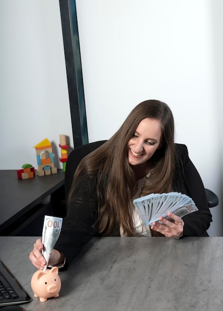 Joyful caucasian businesswoman putting the paper money into piggy bank and smile with happiness for money saving to wealthness in the future of education concept Woman puts in the moneybox cash