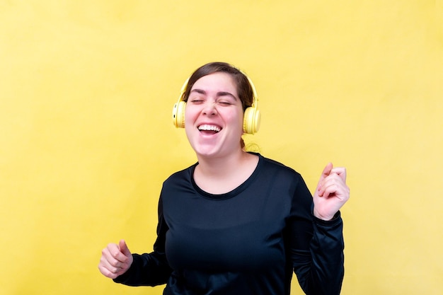 Joyful caucasian woman sings song listens favorite play list via headphones