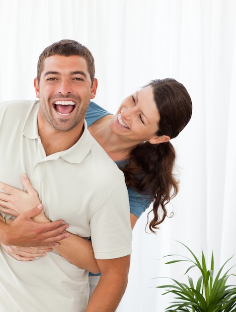 Joyful couple laughing together in the livingroom