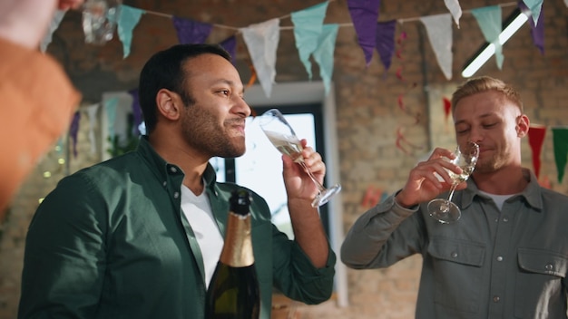 Joyful coworkers drinking champagne celebrating business win in office close up