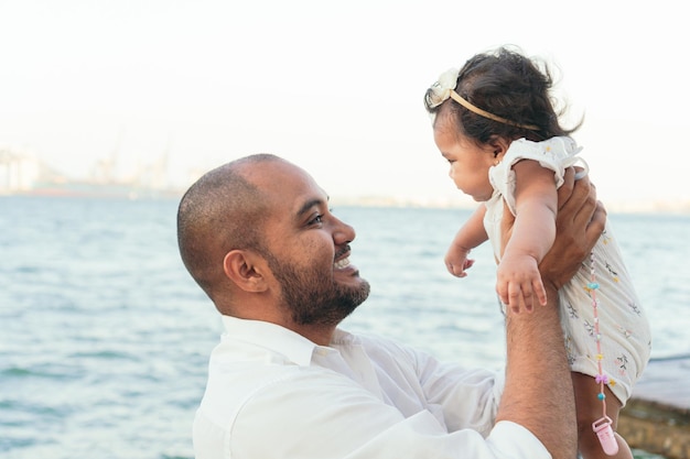 Joyful Father Raises Her Baby Boy In The Air And Smiles At Him