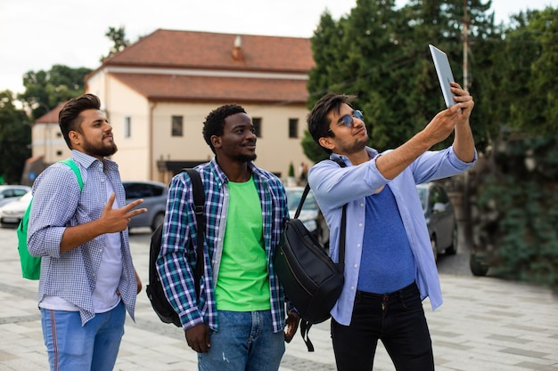 The joyful group of multiethnic students taking a selfie outdoors