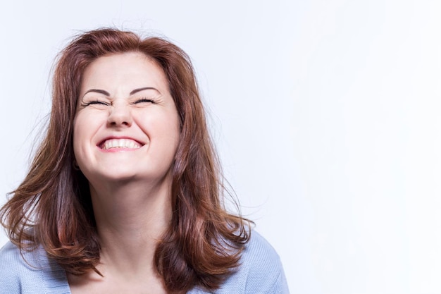 Joyful happy laughing beautiful woman in blue sweater White background Space for text