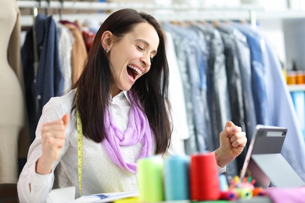 Joyful happy woman seamstress stylist at workplace