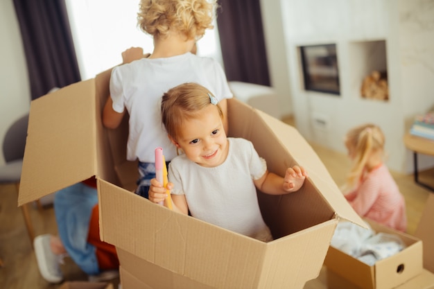 Joyful nice kids sitting together in the box