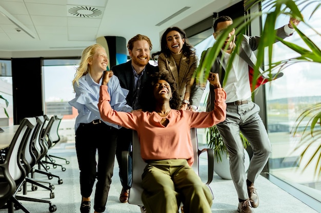 Joyful Office Colleagues Engage in a Playful Chair Race on a Sunny Afternoon