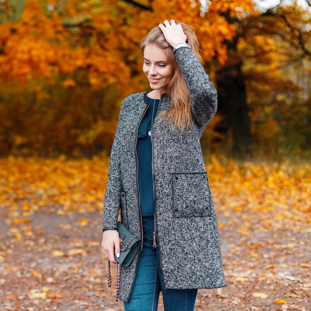 Joyful pretty beautiful young woman with trendy gray coat