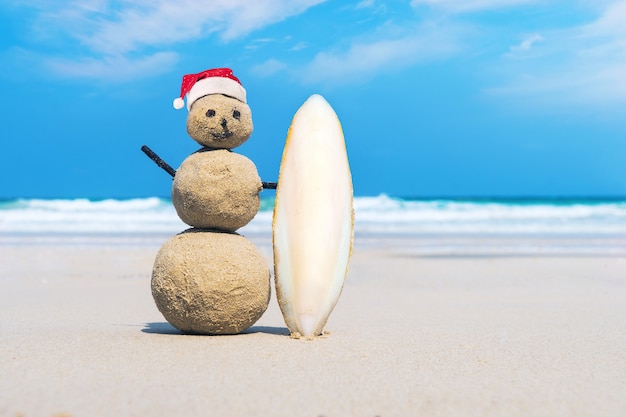 Joyful Sandman of white sand on the clean beach of an exotic island on the background of blue sea and cloudy sky. Sand surfer. creative idea of surfing. the concept of marine sports