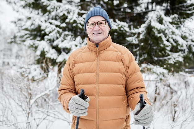 Joyful senior man skiing in park