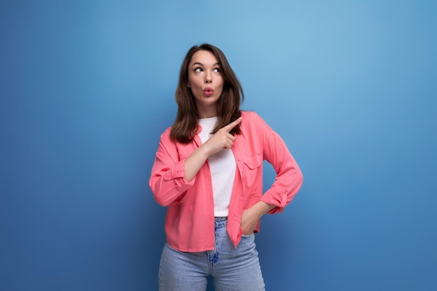 Joyful shocked brunette young woman in casual outfit communicates some idea over isolated background