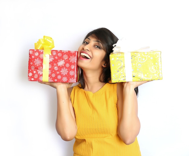 Joyful woman holding boxes with gifts on a white background.