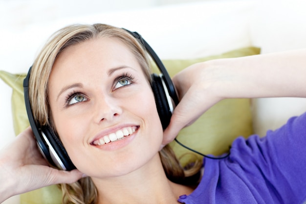 Photo joyful woman  listening to music in the living-room