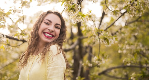 Photo joyful woman smiling in spring blossoming garden