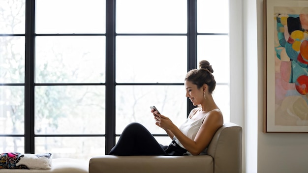 Photo joyful woman using smartphone in modern home