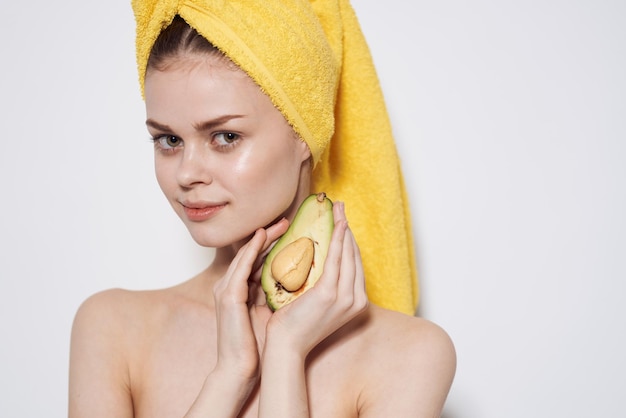 Joyful woman wearing yellow towel on her head avocado vitamins natural cosmetics cropped view