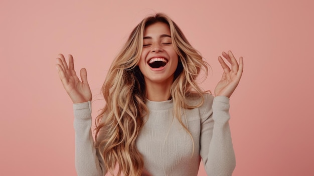 joyful woman with long blonde hair raising her hands with a carefree expression against a pink background