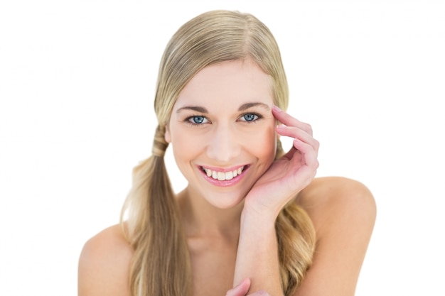 Joyful young blonde model posing holding her head