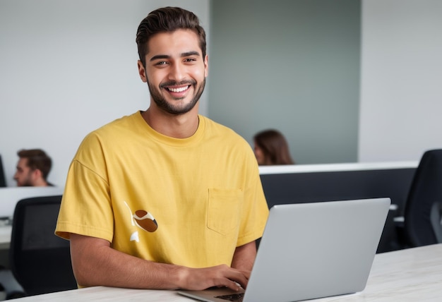 Joyful young man with a laptop in a casual office environment exhibiting a relaxed work atmosphere