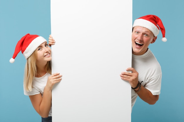 Joyful young Santa couple friends guy and woman in Christmas hat 