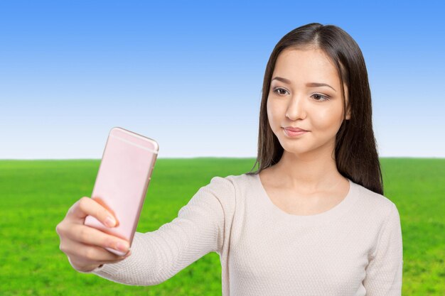 Joyful young women making selfie by her smart phone