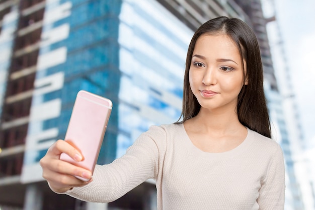 Joyful young women making selfie by her smart phone