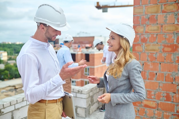 Joyous building inspector talking to a young foreman