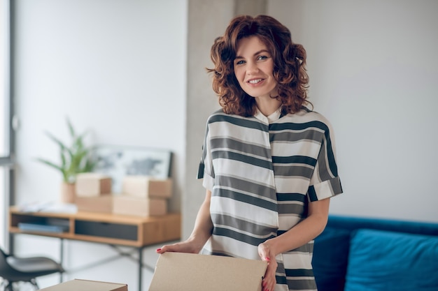 Joyous small business owner packing wares for shipping