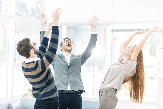 jubilant business team standing in a circle, hands up in rejoice success