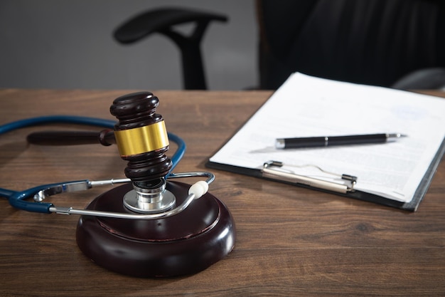 Judge gavel documents and stethoscope on the wooden table