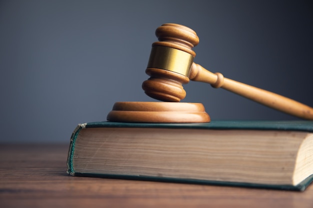 Judge gavel with books on wooden table
