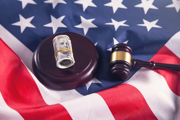 Judge gavel with dollars and American flag.