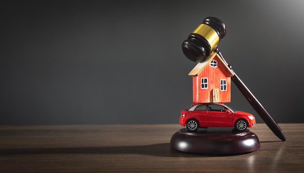 Judge gavel with a house model and toy car on the wooden table