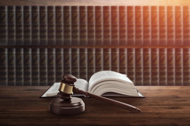 Judge's gavel and a book on a wooden table. 