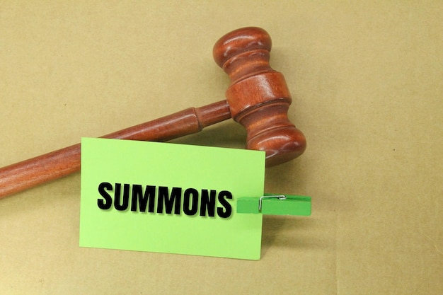 judge's gavel and colored paper with the word SUMMONS an order to appear before a judge