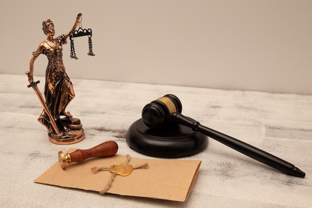 Judge's gavel lady of justice and parchment scroll with seal and stamp on an old wooden table Law and justice concept