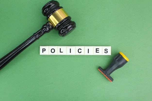 judge's gavel stamp and pen with the word policies the concept of policy or privacy