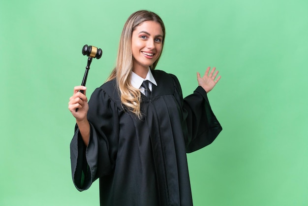 Judge Uruguayan woman over isolated background extending hands to the side for inviting to come