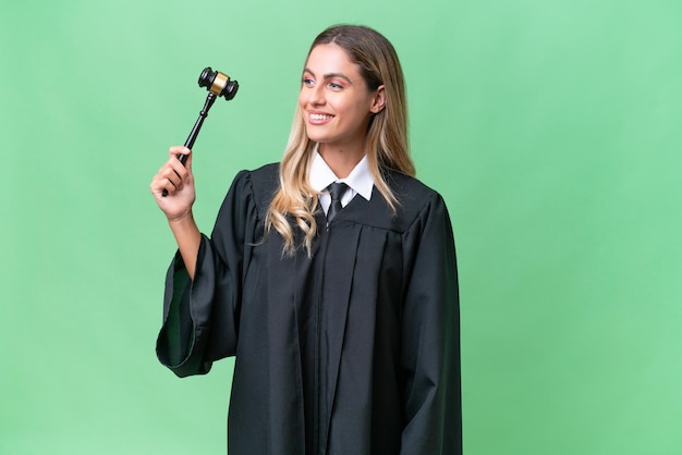 Judge Uruguayan woman over isolated background looking to the side and smiling