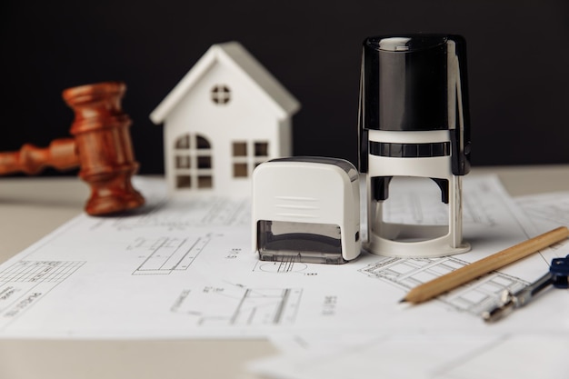 Judge wooden gavel stamp and model of house with blueprint