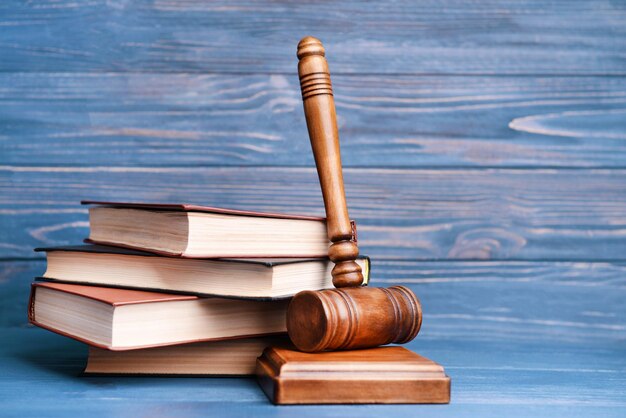 Photo judges gavel and books on wooden wall background