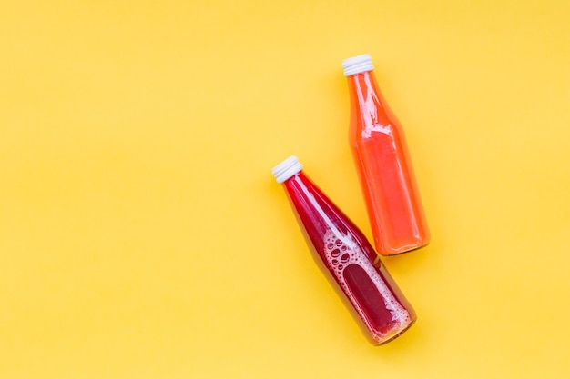 Juice Bottle Mock-Up, two gradient juice bottles on yellow surface