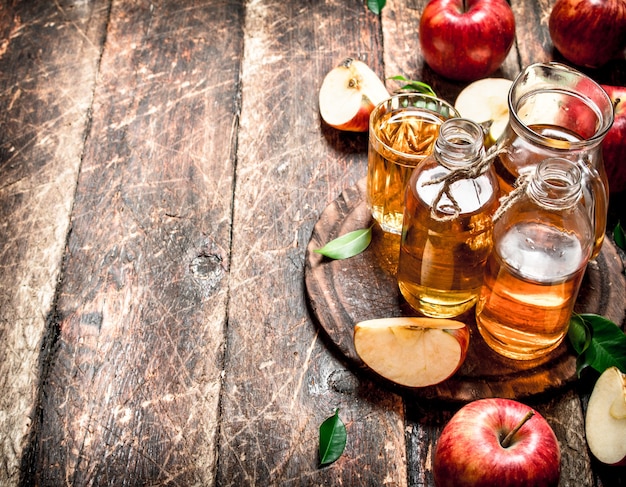 juice of fresh, red apples on wooden table.