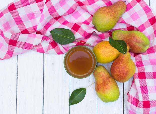 Juice from autumn pears and fresh pears on a white rustic table. Top view. Copy space.