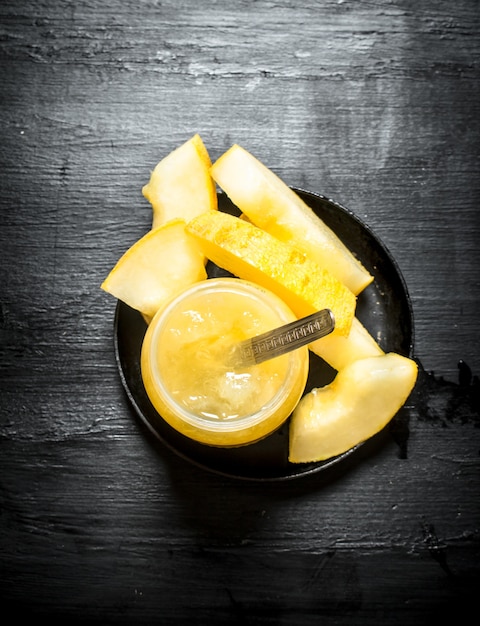 The juice from the melon . On the black wooden table.