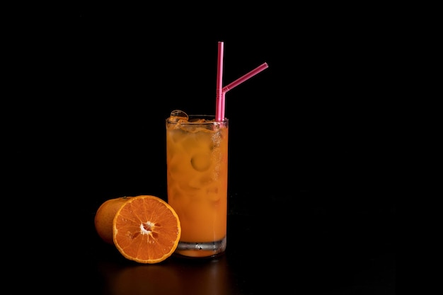 Juice with ice cube in a glass on black background Refreshing drink concept