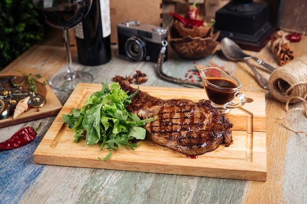 Photo juicy appetizing beef steak with sauce and greens